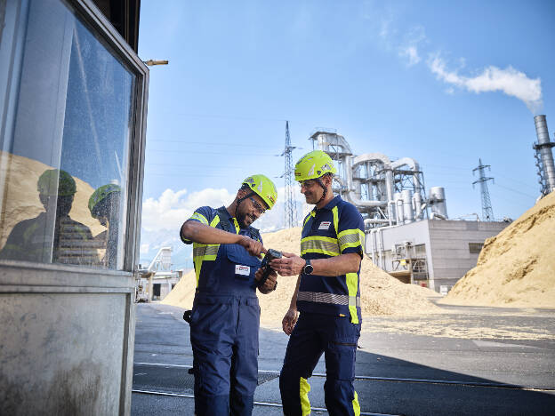 Unternehmensfoto Männer mit Schutzkleidung und Holzwerkstoffe im Hintergrund tauschen sich aus - Businessfotograf Businessfotografie Christian Vorhofer
