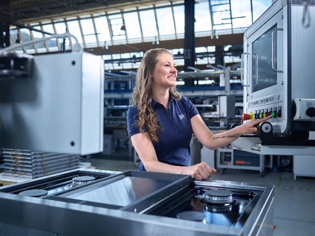 Produktionsmitarbeiterin bedient Produktionsanlage, Industriefotografie Christian Vorhofer, Kunde GWM-Gerätewerk Matrei