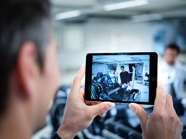 Mann schaut durchs Tablet auf Arbeitssituation Industrie - Businessfotograf Businessfotografie Christian Vorhofer