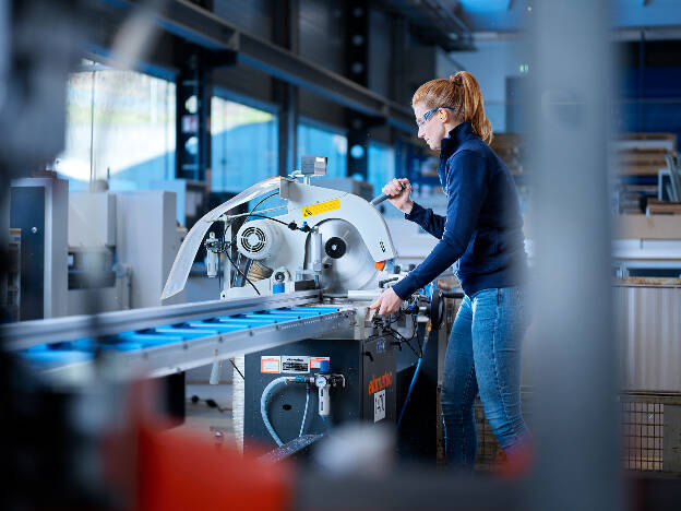 Mitarbeiterin bedient Aluminiumsäge, Arbeitssituation, Metallbau, Metallverarbeitung, Industreifotografie, Frauen in technischen Berufen, Kunde GWM-Gerätewerk Matrei