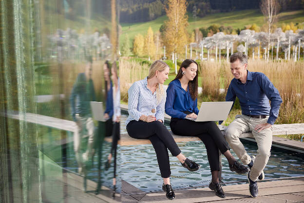 Unternehmensfoto Unternehmensfotografie Mitarbeiter sitzen mit Laptop im Park bei einer Besprechung - Businessfotograf Businessfotografie Christian Vorhofer