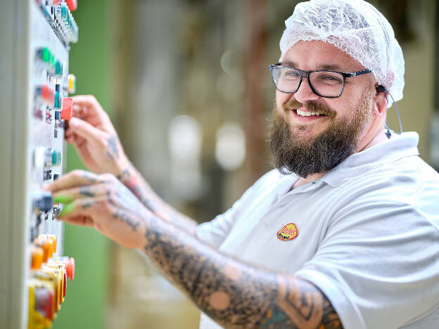 Unternehmensfoto Mann mit Tatoo und Brille bedient Maschine Industrie Recheis - Businessfotograf Businessfotografie Christian Vorhofer