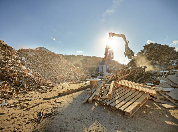 Baumaschine mit Greifer im Gegenlicht bei Trennung der Holzarten, Wiederverwertung von Rohstoffen, Recycling, Industriefotografie Christian Vorhofer, Kunde Egger