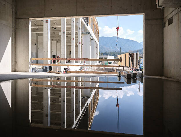 Spiegelung Baustelle, Holzkonstruktion Montage Fassadenelemente, Industriefotografie Christine Vorhofer, Kunde Egger