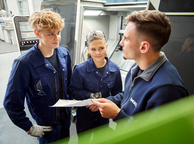 Unternehmensfoto Lehrlinge besprechen sich gerade bei Engel - Businessfotograf Businessfotografie Christian Vorhofer