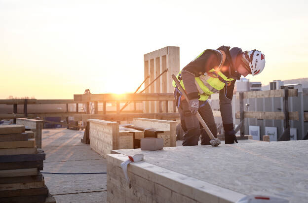 Zimmermann bei Sonnenaufgang, Baustelle Holzkonstruktion, Industriefotografie Christian Vorhofer, Kunde Egger