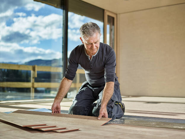 Bodenleger bei der Verlegung eines Laminatboden, Industriefotografie Christian Vorhofer, Kunde Egger