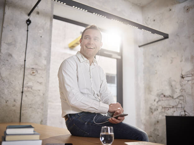 Unternehmensfoto Mann sitzt locker auf dem Tisch und telefoniert - Businessfotograf Businessfotografie Christian Vorhofer