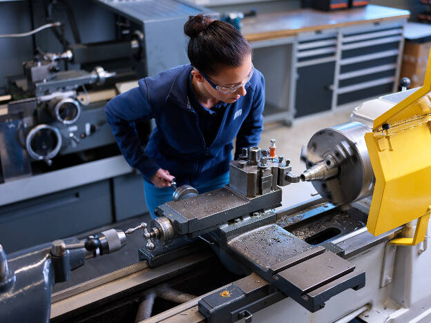 Mitarbeiterin bedient Drehbank, Arbeitssituation, Metallbau, Metallverarbeitung, Industreifotografie, Frauen in technischen Berufen, Kunde GWM-Gerätewerk Matrei