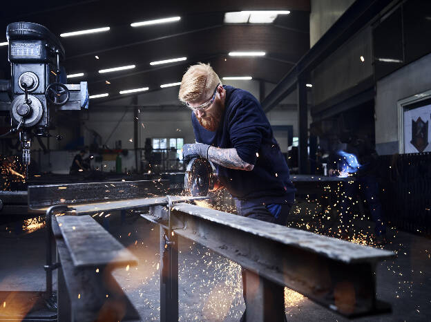 Schlosserwerkstatt, Schlosser mit Winkelschleifer, Arbeitswelt Handwerk und Gewerbe, Funkenflug, Industrie Fotografie Christian Vorhofer, Kunde WKO-Tirol