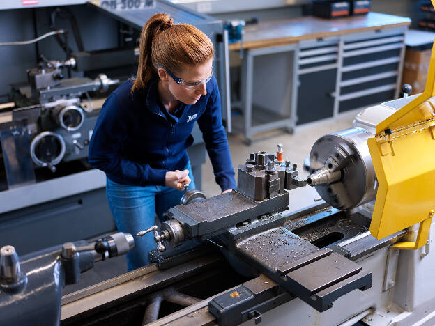 Mitarbeiterin bedient Drehbank, Arbeitssituation, Metallbau, Metallverarbeitung, Industreifotografie, Frauen in technischen Berufen, Kunde GWM-Gerätewerk Matrei