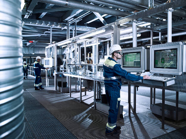 Schaltzentrale einer Chemieanlage, Arbeiter kontrollieren Arbeitsprozesse über Monitore, Industriefotografie Christian Vorhofer, Produktionsstandort Rumänien, Kunde Egger 