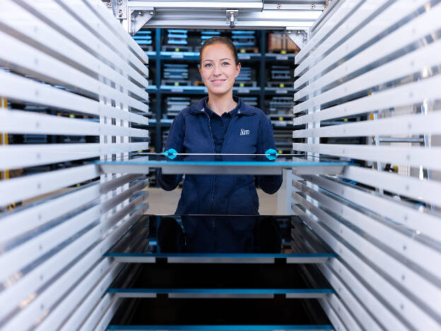 Arbeiterin schiebt fertiges Cerankochfeld in Transportbox, Industriefotografie Christian Vorhofer, Kunde GWM Gerätewerk Matrei