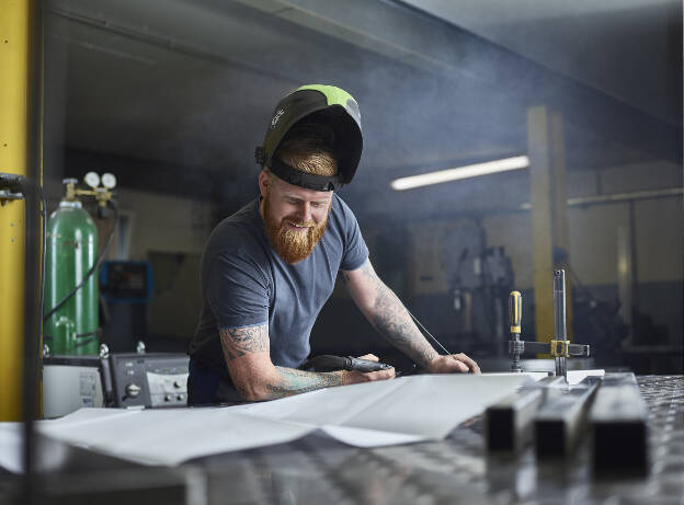 Metallbauer Schlosser mit Schweißhelm und Plan, Schlosserei, Edelstahl, Industriefotografie Christian Vorhofer, Kunde WKO Tirol